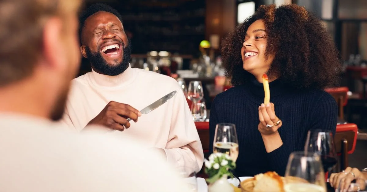 Friends sharing a joyful meal at a restaurant in London, illustrating the city's lively dining experience.