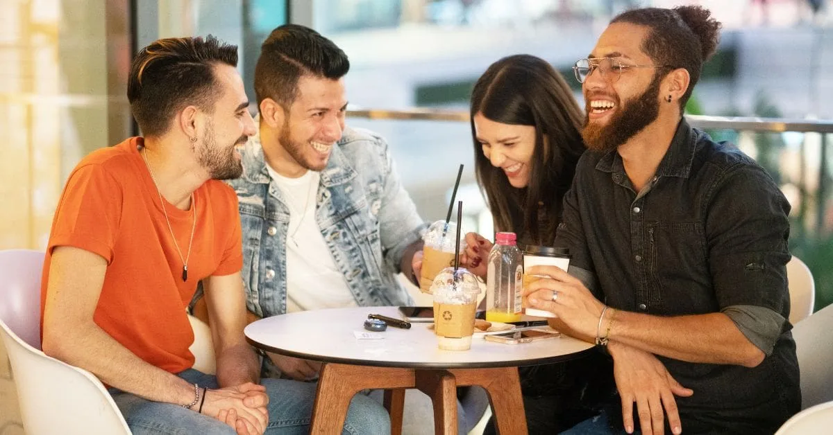 Group of friends enjoying drinks and laughter at a trendy café in London, showcasing the vibrant social food scene.