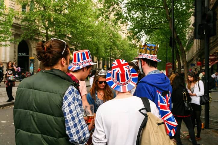 London, UK - 29 April, 2011: color image depicting spectators watching the Royal Wedding of Prince William and Kate Middleton in Trafalgar Square in central London, UK. The people are wearing brightly colored red, white and blue union jack British hats. Room for copy space.