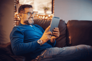 mature man sitting on sofa using a tablet